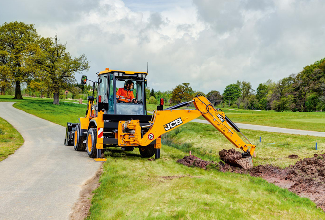 3CX Compact Backhoe Loader excavating grass bank
