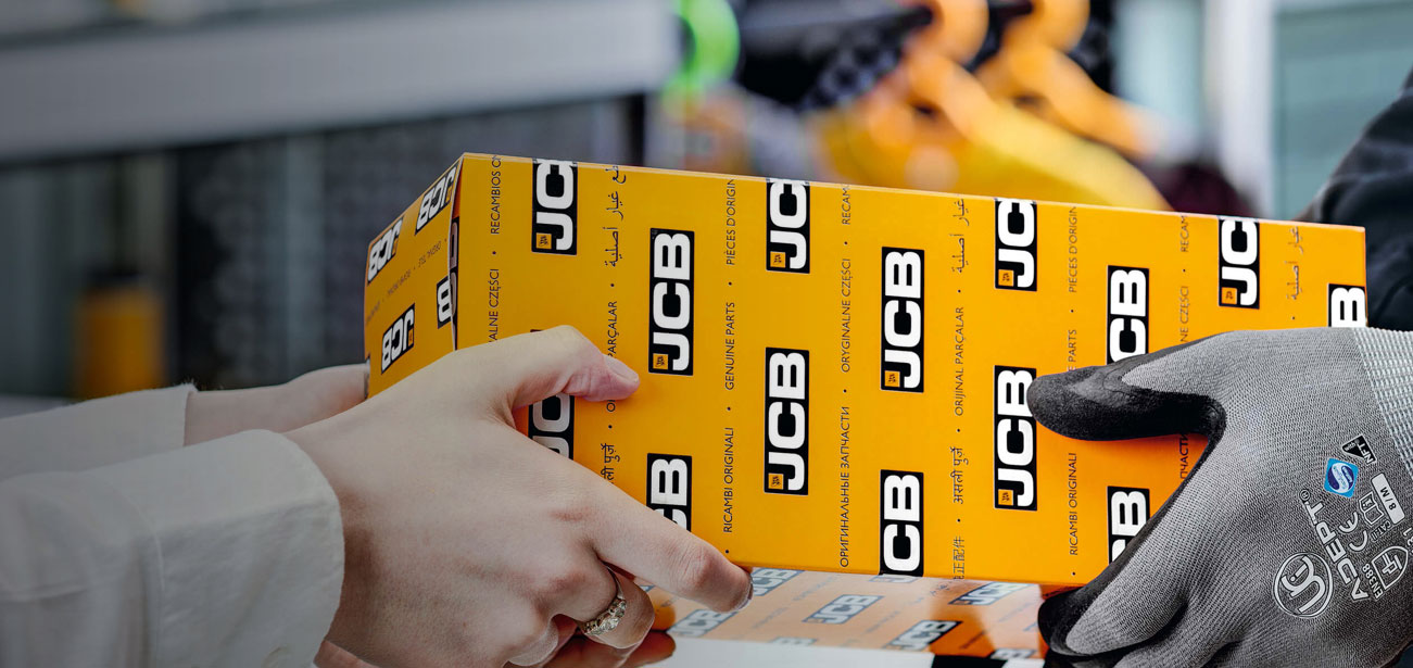 Parts person handing a customer a JCB box of parts