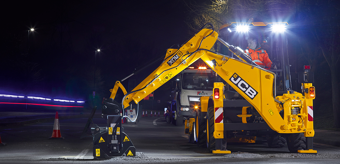 JCB 3CX compact repairing a road