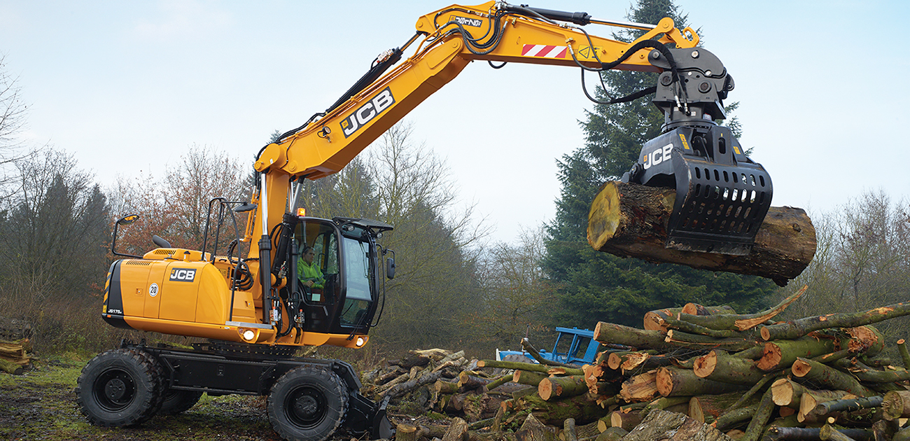JCB JS175W lifing a log with a grab