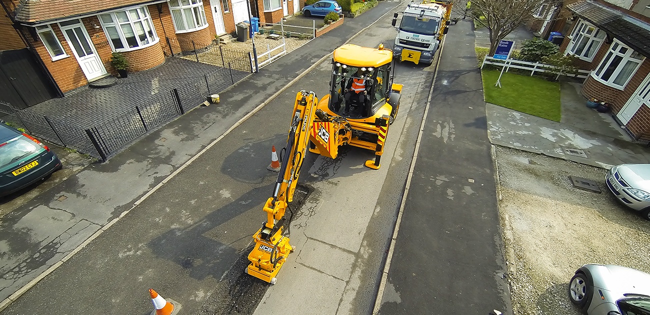 JCB 3CX backhoe repairing a road