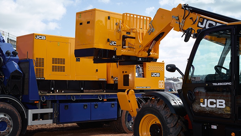 generator being loaded onto a lorry using a telehandler