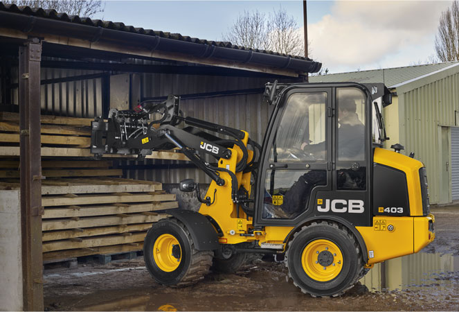 A 403 Wheel Loading Shovel lifting some wood