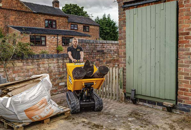 JCB HTD-5 Dumpster being pushed along with a skip full of logs
