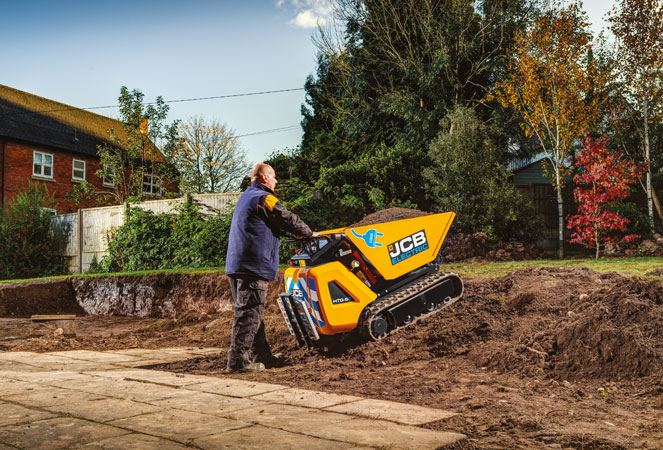 JCB HTD-5E Dumpster with full skip being pushed up a dirt slope