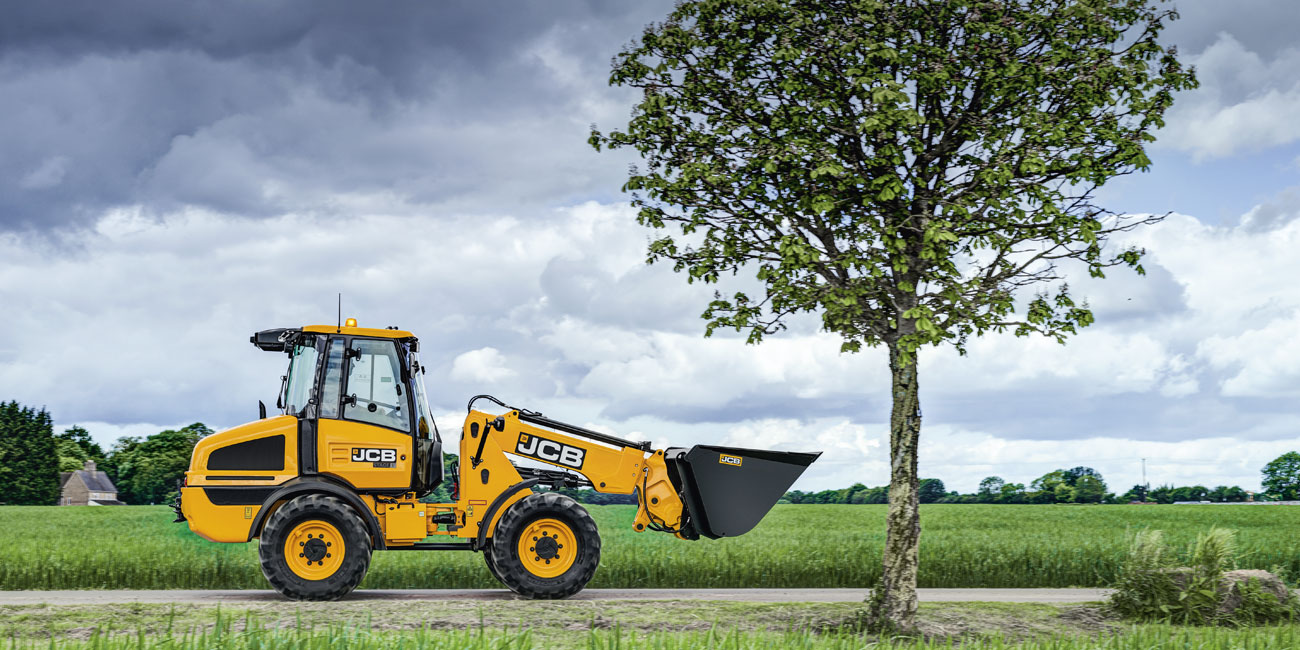 JCB Telescopic Wheel Loader driving past a tree