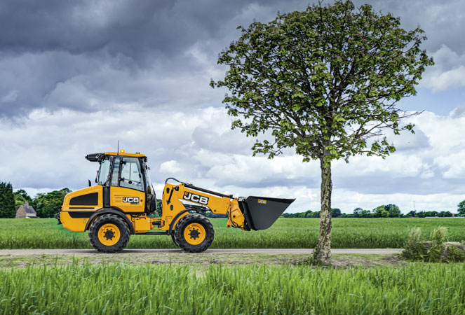 JCB TM180 driving along road past a tree