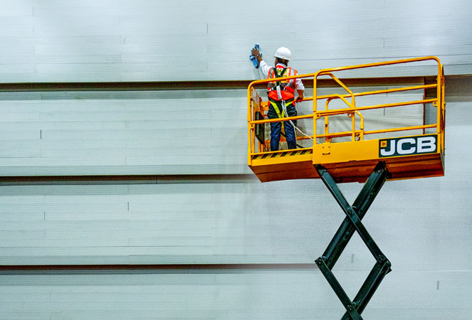 JCB S4550E with worker in cleaning a wall